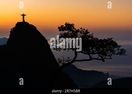Rio de Janeiro, Brazil - June 10, 2023: Christ the Redeemer statue on top of the Corcovado mountain on sunrise with colorful sky. Stock Photo