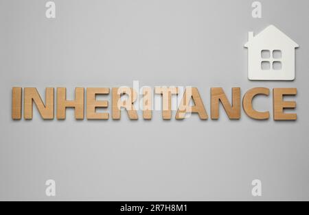 Word Inheritance made with letters and house model on wooden background ...