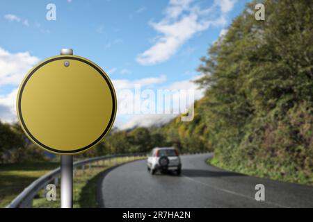 Blank yellow road sign on asphalt highway, space for text Stock Photo