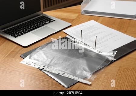 File folder with punched pockets on wooden table Stock Photo