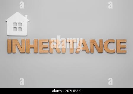 Word Inheritance made with letters and house model on wooden background ...