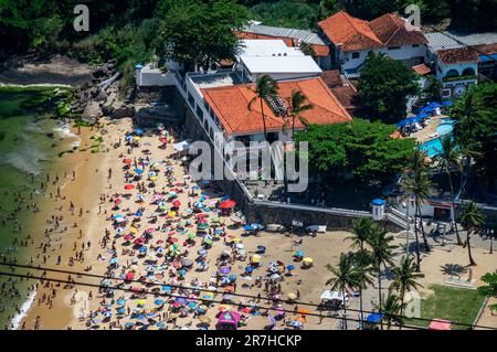 Partial view of the crowded Praia Vermelha beach, near Circulo Militar building as saw from Urca hill observation deck under summer sunny day. Stock Photo