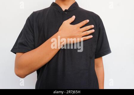 The man in the black shirt placed one hand on his chest in greeting Stock Photo