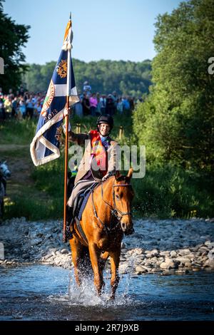 Selkirk, Scotland. Friday June 16, 2023.  Royal Burgh Standard Bearer, Thomas Bell carries the Burgh Standard as he fords the River Ettrick. Selkirk commemorates and celebrates its history at the annual Common Riding, held on the second Friday after the first Monday in June, when the town's boundaries or marches are ridden. Credit:Rob Gray/Alamy Live News Stock Photo