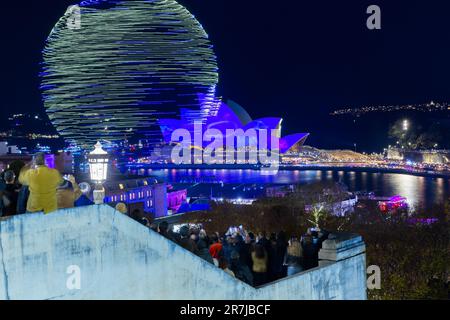 Crowds gather to witness the 'Written in the Stars' light show and drone display at the 2023 'Vivid Sydney' Festival in Sydney, Australia. Stock Photo