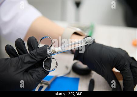 Syringe with anesthetic in hands of dentist preparing anelgesic injection por painless teeth treatment in dental clinic Stock Photo