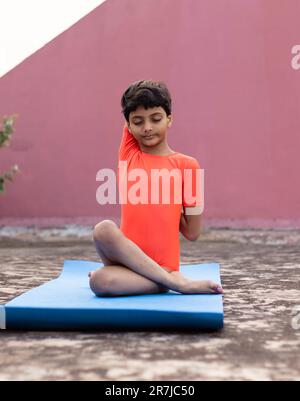 An Indian girl child practicing yoga on yoga mat outdoors Stock Photo -  Alamy