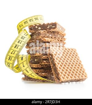 Sweet chocolate wafer and measuring tape isolated on the white background. Stock Photo
