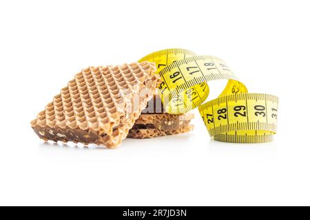 Sweet chocolate wafer and measuring tape isolated on the white background. Stock Photo