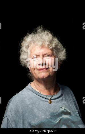 An older Canadian women with white hair stands for a close cropped portrait in a studio built on the sidewalk on the corner of Broadview Avenue and Gerrard Street Avenues in one of Stock Photo