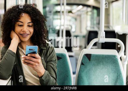 Young relaxed woman commuting sitting and using her phone. Stock Photo
