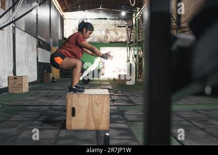 Latin woman box jumping in gym doing crossfit. Perú. Stock Photo