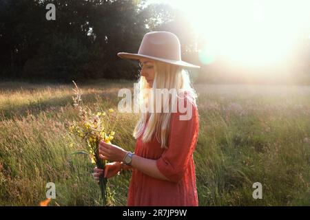 Portrait of a young blonde woman with a bouquet of wildflowers Stock Photo