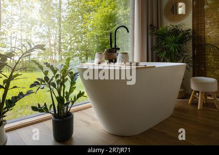 bedroom interior with white bathtub by the window Stock Photo
