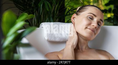 wellness spa background. woman relaxing in bath and enjoying body and skin treatments. banner with copy space Stock Photo