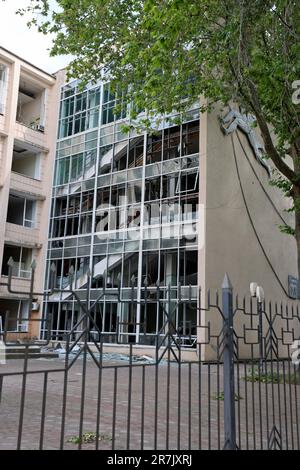 Damaged facade, broken windows of the house. War between Ukraine and Russia. Shell fragments damaged university building. Stock Photo