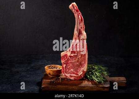 Raw Tomahawk beef steak and spices. Ready for grilling Stock Photo
