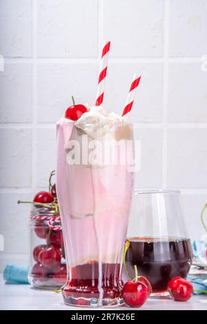 Sweet homemade cherry-cola milkshake with whipped cream, ice cream, cold cola, fresh cherries and syrup Stock Photo
