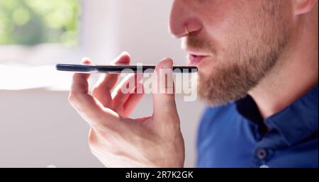 Young Man Using Voice Recognition Function On Mobile Phone Stock Photo