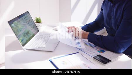 Business Accountant Using Finance Chart Document And Calculator Stock Photo