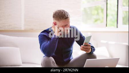 Man With Neck Pain Sitting Using Mobile Phone Stock Photo