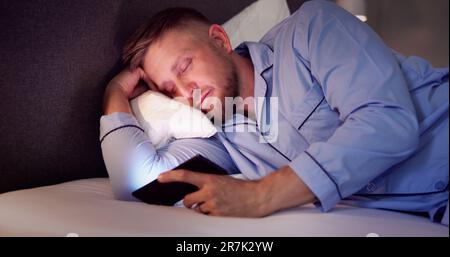 Man In Bed With Mobile Phone At Night Stock Photo