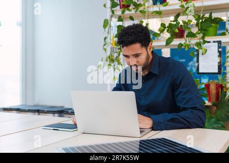 Businessman using laptop at desk in office Stock Photo