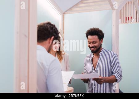 Smiling business colleagues discussing document in office Stock Photo