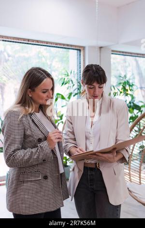 Two businesswomen reviewing documents in office Stock Photo