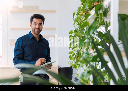 Portrait of businessman in office using digital tablet Stock Photo