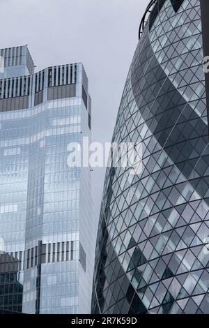 30 St Mark Axe, affectionately nicknamed the Gherkin contrasts in design shape against 22 Bishopspage in the City of London on 25th May 2023 in London, United Kingdom. The City of London is a city, ceremonial county and local government district that contains the primary central business district CBD of London. The City of London is widely referred to simply as the City is also colloquially known as the Square Mile. Stock Photo