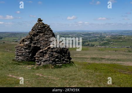 Stone cairn on Nab Hill at the top of Ovenden Moor which also operates as a shelter due to the high winds that are experienced up on the moorland and the changes of weather on 5th June 2023 in Ogden near Halifax, United Kingdom. Stock Photo