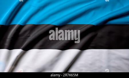 Estonia flag with big folds waving close up under the studio light indoors. The official symbols and colors in fabric banner Stock Photo