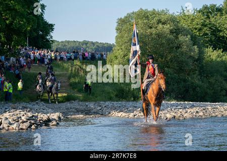 The Royal Burgh Standard Bearer Thomas Bell fords the River Ettrick during the Selkirk Common Riding, a centuries-old tradition in the royal burgh of Selkirk in the Scottish Borders. Picture date: Friday June 16, 2023. Stock Photo