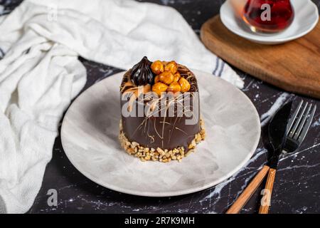 Caramel and chocolate cake on dark marble table. Delicious cake on plate Stock Photo