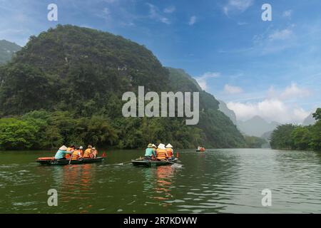 Ninh Binh, Vietnam-April 2023; View of sampan rowing boats with tourists on cave tours on Red River Delta in landscape of Trang An Stock Photo