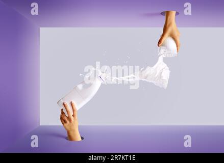 Pop art photography. Female hand sticking out from circle hole with bottle pouring milk into glass. Stock Photo