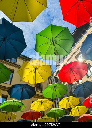Colorful umbrellas float in the sky and decorate the street. Multi colored background. Concept of tourism Stock Photo