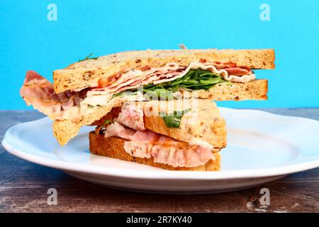 Bacon lettuce and tomato BLT sandwich isolated on a white plate Stock Photo