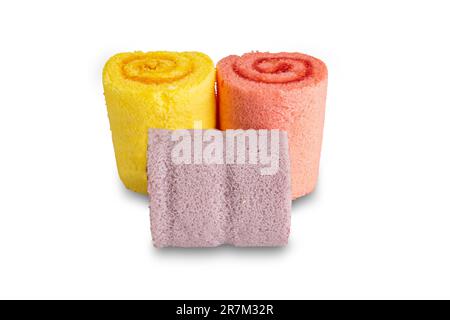 Three homemade roll cakes of different color isolated on white background with clipping path. Stock Photo