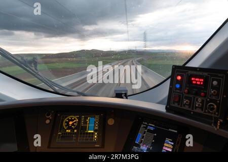 Motion blur view of railway from inside high speed train at evening and control panel of the locomotive Stock Photo