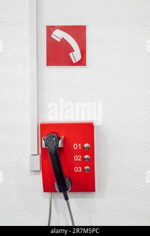 The red emergency telephone in the office building. Telephone system for calling the fire alarm. Stock Photo