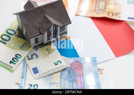Euro banknotes and symbolic small toy house. Buying property and mortgage Stock Photo