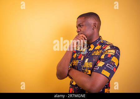Thoughtful African man with hand on chin, studio photo with copy space Stock Photo