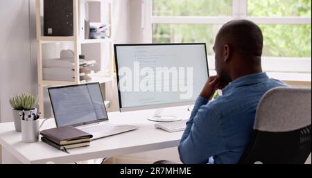 Computer Programmer Writing Program Code On Computer In Office Stock Photo
