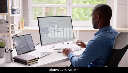 Computer Programmer Writing Program Code On Computer In Office Stock Photo