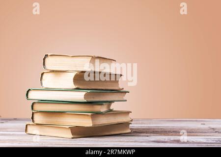 Book with opened pages in shape of heart and stacked books on reading desk in library. National library, books lovers day or month. Back to school or Stock Photo