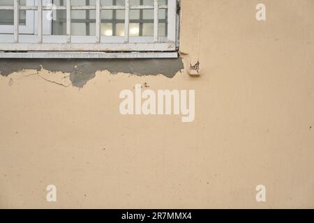 Part of the window with bars on the stone wall. The surface of a broken plastered wall. With space to copy. High quality photo Stock Photo