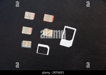 several sim cards lie on a black background Stock Photo