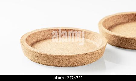 Two cork wood saucers close-up on a white background with shadows Stock Photo